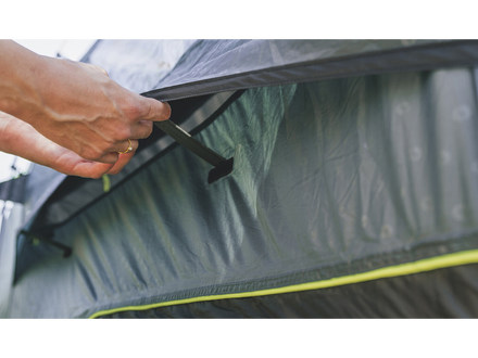 hands opening an air vent on a tent 