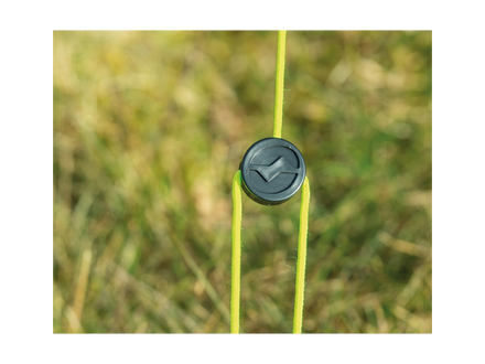 Black plastic clip attached to a green string with a blurred grass background