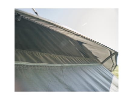 Close-up of a tent with a clear rainfly and white groundsheet on a light background
