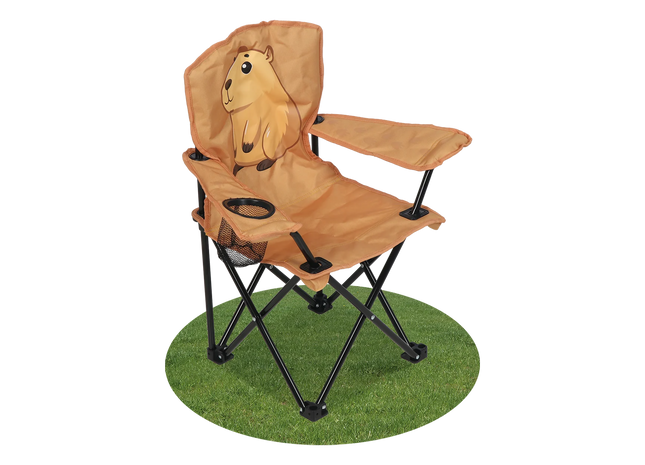 A tan folding camp chair with a cartoon capybara on the backrest, black metal legs, and a small side cup holder, shown on a green circular patch of artificial grass against a white background.