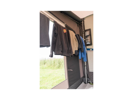 Clothes hanging on an outdoor clothesline attached to a vehicle.