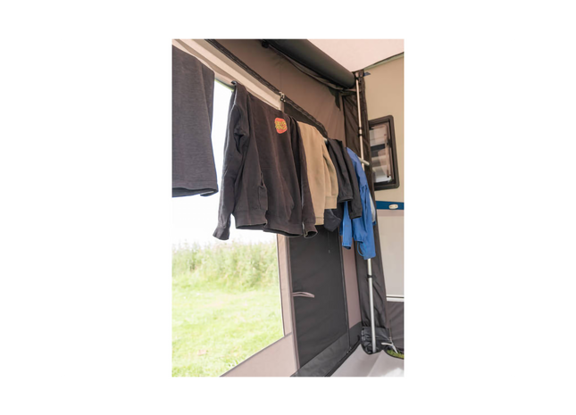 Clothes hanging on an outdoor clothesline attached to a vehicle.