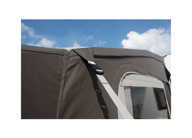 Close-up of a brown awning with storm straps on a clear sky background