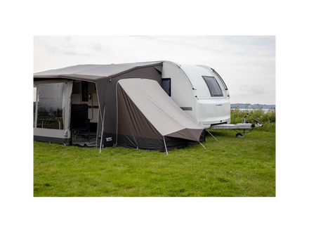 Caravan with an extended awning on a grassy field