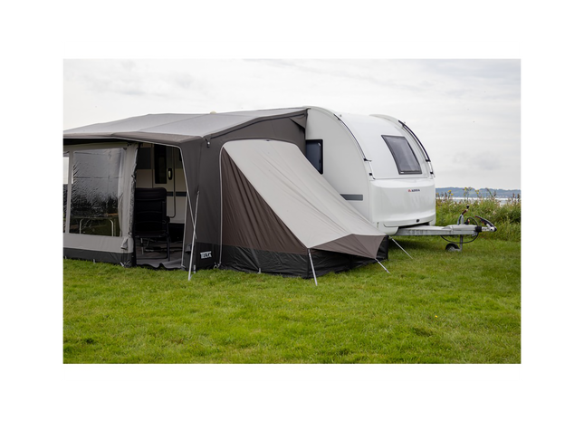 Caravan with an extended awning on a grassy field