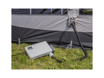 Camping air pump connected to a tent on grass