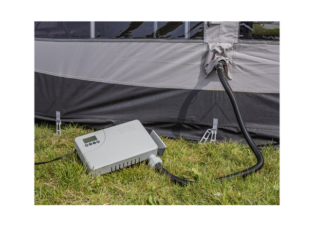 Camping air pump connected to a tent on grass