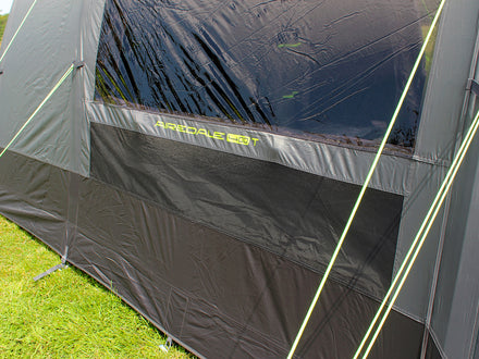 Gray camping tent with a window on a grassy background