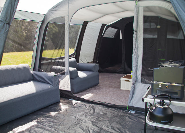 Camping setup with inflatable tent, furniture, and outdoor equipment.