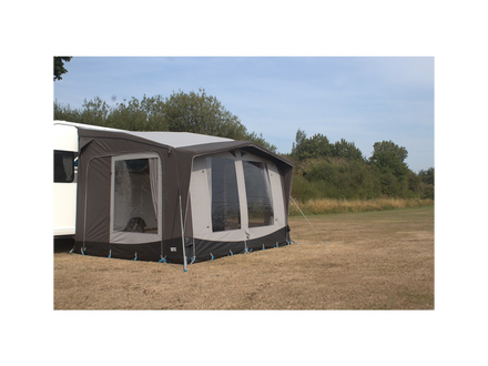 Caravan with an awning extended outdoors on a clear day