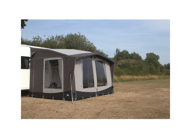 Caravan with an awning extended outdoors on a clear day