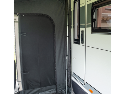 Side view of a caravan with an open door and black mesh screen