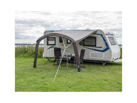 Caravan with an extended awning in a grassy outdoor setting