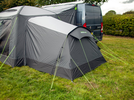 Gray caravan tent with annex attached to a van in an outdoor setting