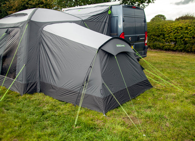 Gray caravan tent with annex attached to a van in an outdoor setting
