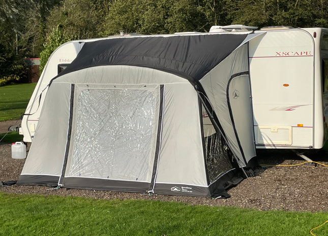 Caravan with an attached awning on a grassy area