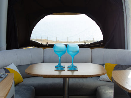 Interior of a vehicle with a table and blue wine glasses