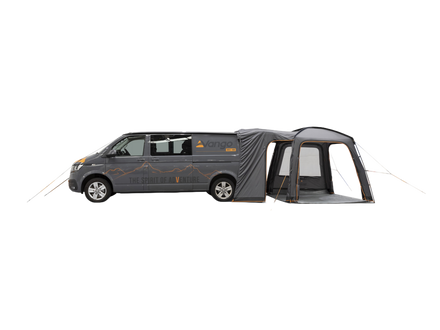 A dark gray van with an attached dark gray camping awning and tent system, shown in profile against a solid white background. The van features orange graphic lines and branding.