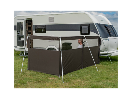 Camper van with a side awning extended on a grassy area
