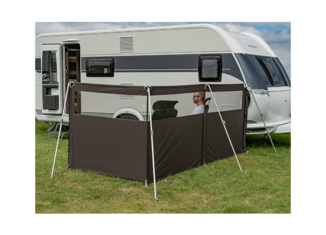 Camper van with a side awning extended on a grassy area