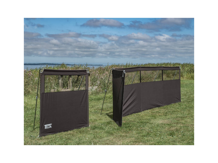 Two black outdoor privacy screens on grass with a cloudy sky background